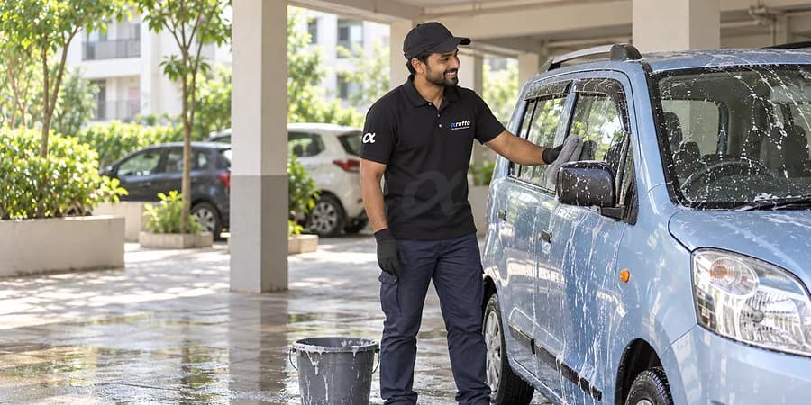 A Rotto mechanic in the black uniform giving a blue hatchback a foam wash