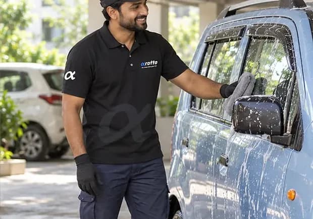 A Rotto mechanic washing a car with soapy water and a bucket